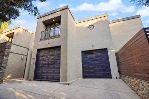 uma casa branca com duas portas de garagem em Villa Alana em Los Angeles