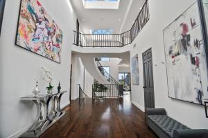 a hallway with white walls and a staircase with a couch at Villa Alana in Los Angeles