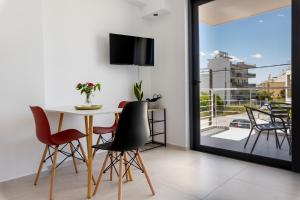 ein Esszimmer mit einem Tisch und Stühlen sowie einem Balkon in der Unterkunft Pagani Blue - Luxury Studio A2 in Faraí