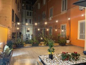 une cour avec des plantes en pot et un bâtiment dans l'établissement SPANISH GARDEN, à Rome