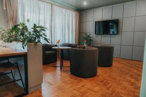 a room with chairs and a table and a tv at Timbó Park Hotel in Timbó