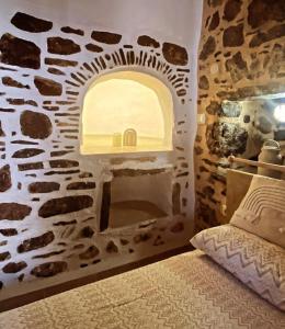 1 dormitorio con pared de piedra y chimenea en August castle house, en Mestá