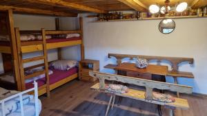a room with two bunk beds and a table at La sălaşul fermecat în Cheile Carasului in Iabalcea