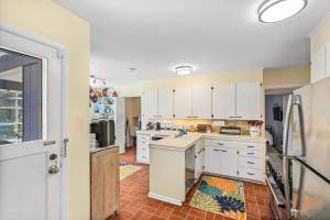 a kitchen with white cabinets and a refrigerator at Magnolia on the Hill in Seattle