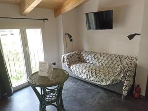 a living room with a couch and a table and a tv at Le Camere Di Paolo in Riomaggiore