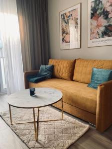 a living room with a couch and a coffee table at Golden Apartment Lodz, Zdrowie in Łódź