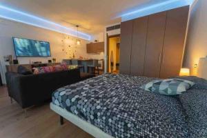 a bedroom with a large bed and a couch at Appartamento accogliente vicino stazione in Desio