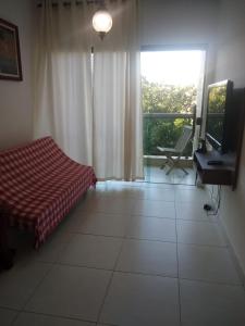 um quarto com uma cama, uma secretária e uma janela em Apto na Praia do Forte em Cabo Frio