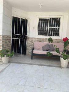 a couch sitting on a porch in front of a window at Casa Carolina in Santa Marta