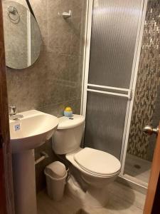 a bathroom with a toilet and a sink and a shower at Casa Carolina in Santa Marta