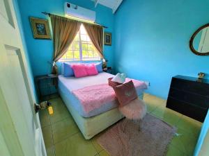 ChoiseulComfort Suites Three Bedroom Apartment的一间卧室配有一张带粉色床单的床和一扇窗户。