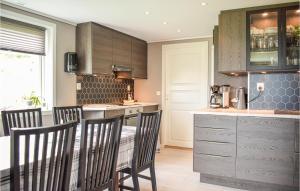 a kitchen with a table and chairs in a room at 5 Bedroom Lovely Home In Bjoa in Utbjoa