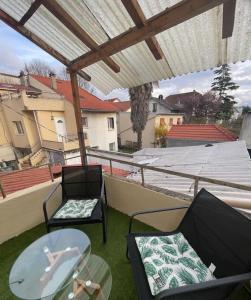 a patio with two chairs and a table on a roof at Le floquet in Vitry-sur-Seine