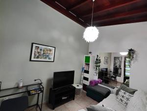 a living room with a couch and a tv at loft patri Caleta de Fuste in Caleta De Fuste