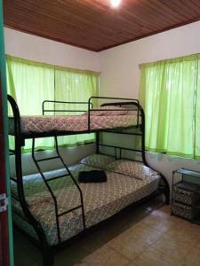 2 beliches num quarto com cortinas verdes em La casita JSL 