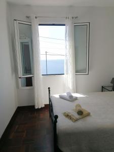 - une chambre avec un lit et une grande fenêtre dans l'établissement Westerland House, à Ribeira Brava