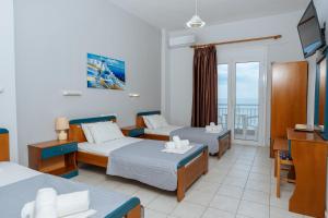 a hotel room with two beds and a television at Hotel Galaxias in Paralia Katerinis