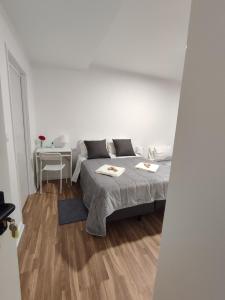 a white room with a bed and a table with a chair at Habtiar Guest House in Braga