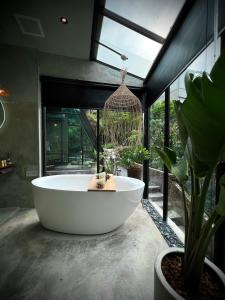 a large bath tub in a bathroom with a plant at Twilight Forest in Jiufen