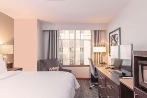 ein Hotelzimmer mit Bett, Schreibtisch und Fernseher in der Unterkunft CopperLeaf Hotel BW Premier Collection in Appleton + 12 Fotos
