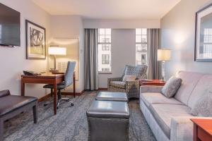 a living room with a couch and a desk in a hotel room at CopperLeaf Boutique Hotel & Spa; BW Premier Collection in Appleton