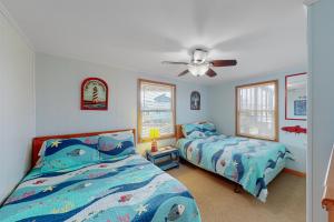 a bedroom with two beds and a ceiling fan at Dancing Dolphin 106 in Avon