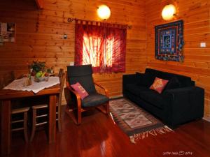 ein Wohnzimmer mit einem Sofa, einem Tisch und einem Stuhl in der Unterkunft Bikta BaMata in Naharija