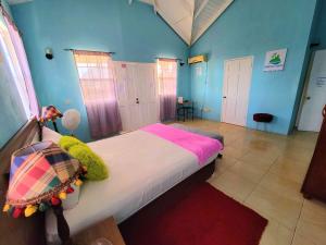 - une chambre avec un lit dans une pièce aux murs bleus dans l'établissement Comfort Suites - One Bedroom Apartment, à Choiseul
