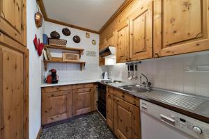 a kitchen with wooden cabinets and a sink at Chesa Pradash - Celerina in Celerina