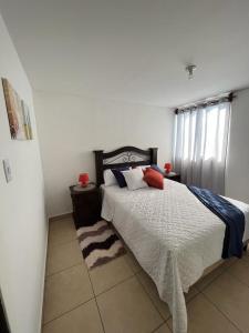 a bedroom with a large bed and a window at Apartamento Tesoro-Ciudad de Guatemala zona 2 de Mixco in Guatemala