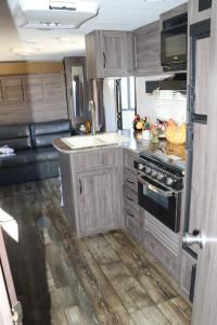 una cocina con armarios de madera y una estufa en una cabaña en RV quiet place in the mountain, en Hemet