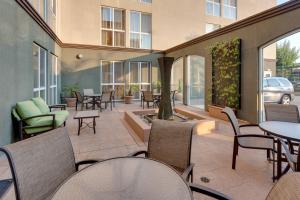 un patio con tavoli, sedie e fontana di Fairfield Inn & Suites by Marriott San Francisco Airport a Millbrae