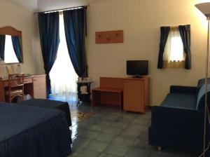een woonkamer met een bank en een tv bij Hotel Floridiana in Amalfi