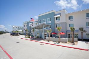 an exterior view of a hotel with an american flag at TownePlace Suites by Marriott Galveston Island in Galveston