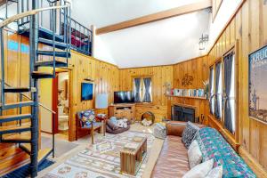 a living room with wooden walls and a spiral staircase at Idyllwild Retreat in Idyllwild