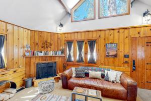 a living room with a leather couch and a fireplace at Idyllwild Retreat in Idyllwild