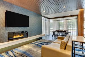 a living room with a fireplace and a tv at Fairfield Inn & Suites by Marriott Dallas Love Field in Dallas