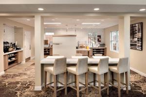 een keuken met een grote witte tafel en stoelen bij Residence Inn by Marriott West Springfield in West Springfield