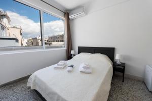 sypialnia z łóżkiem i dużym oknem w obiekcie ATHENS COMMERCIAL w Atenach