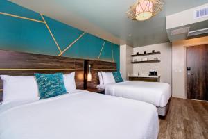 a hotel room with two beds and a blue wall at Marea Sol Hotel in Santa Cruz