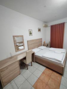 Un dormitorio con una cama, un escritorio y un espejo. en Lovely Home Rooms Center, en Mostar