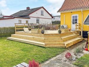 a large wooden deck in a yard next to a house at 6 person holiday home in Tranek r in Tranekær