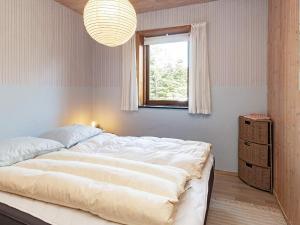 Sønder YdbyにあるHoliday Home Pøt Strandby XIVの窓付きの客室で、白い大型ベッド1台が備わります。