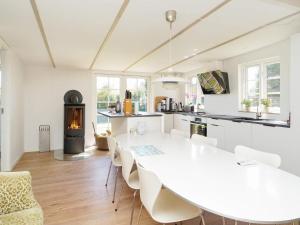 a white kitchen with a white table and chairs at 6 person holiday home in Kalundborg-By Traum in Kalundborg