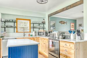 a kitchen with wooden cabinets and blue walls at Beach Oasis in Seaside