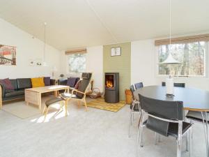 a living room with a table and chairs and a fireplace at 6 person holiday home in Vig in Vig