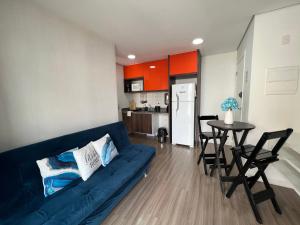 a living room with a blue couch and a table at SeuLar 911 o conforto de um lar em qualquer lugar in São Paulo