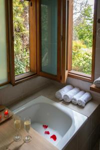 a bathroom with a tub with two glasses of wine at Casa Cielo en Chena Magica in Maipú
