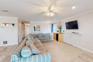 a living room with a couch and a flat screen tv at Flood Reef Getaway in Pensacola