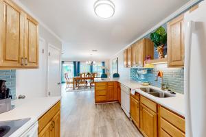 a kitchen with wooden cabinets and a dining room at Flood Reef Getaway in Pensacola